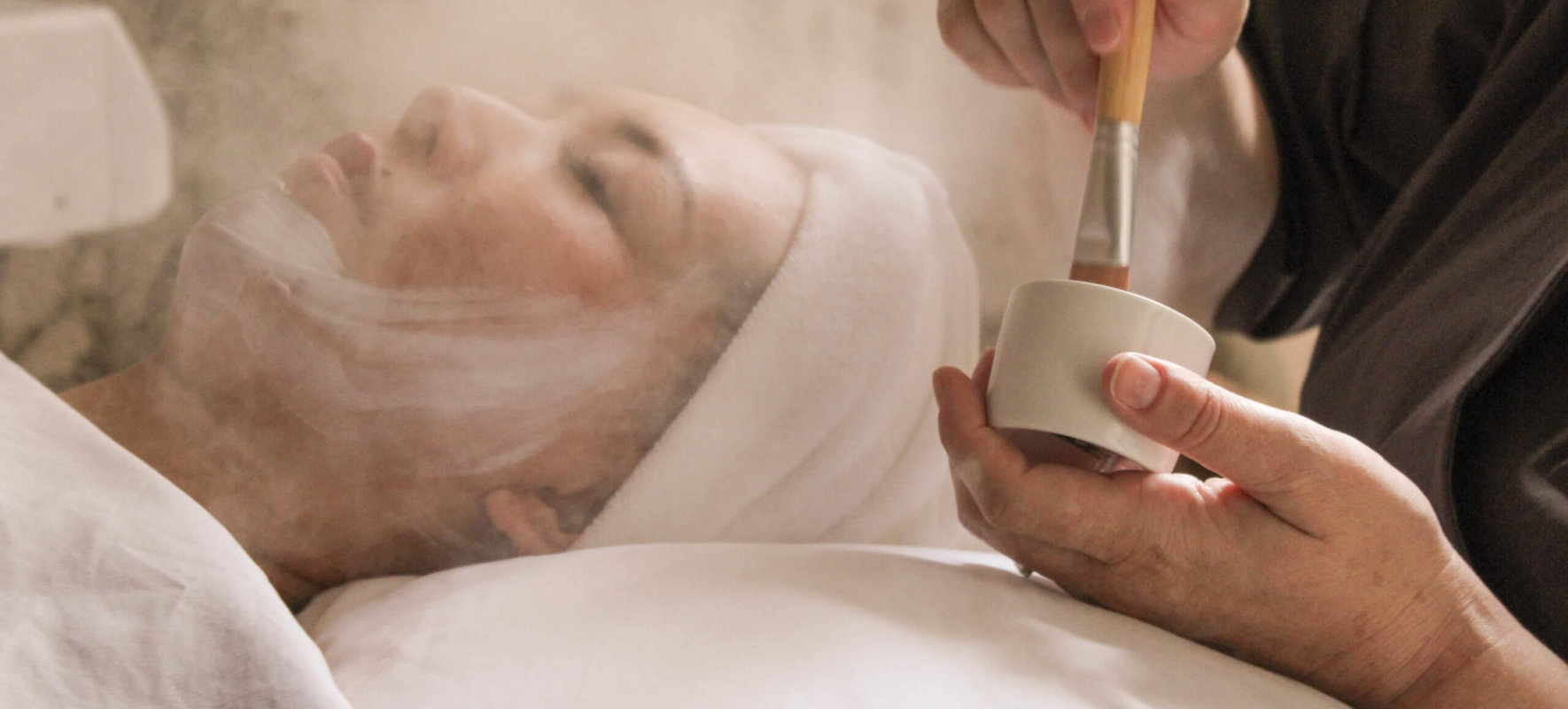 Woman receiving spa facial treatment