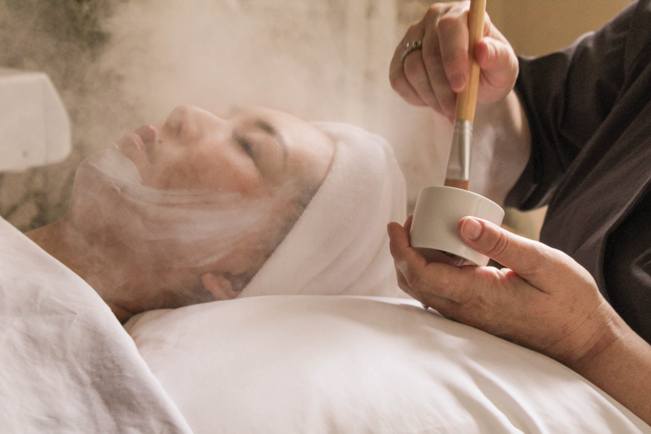 Woman receiving spa facial treatment
