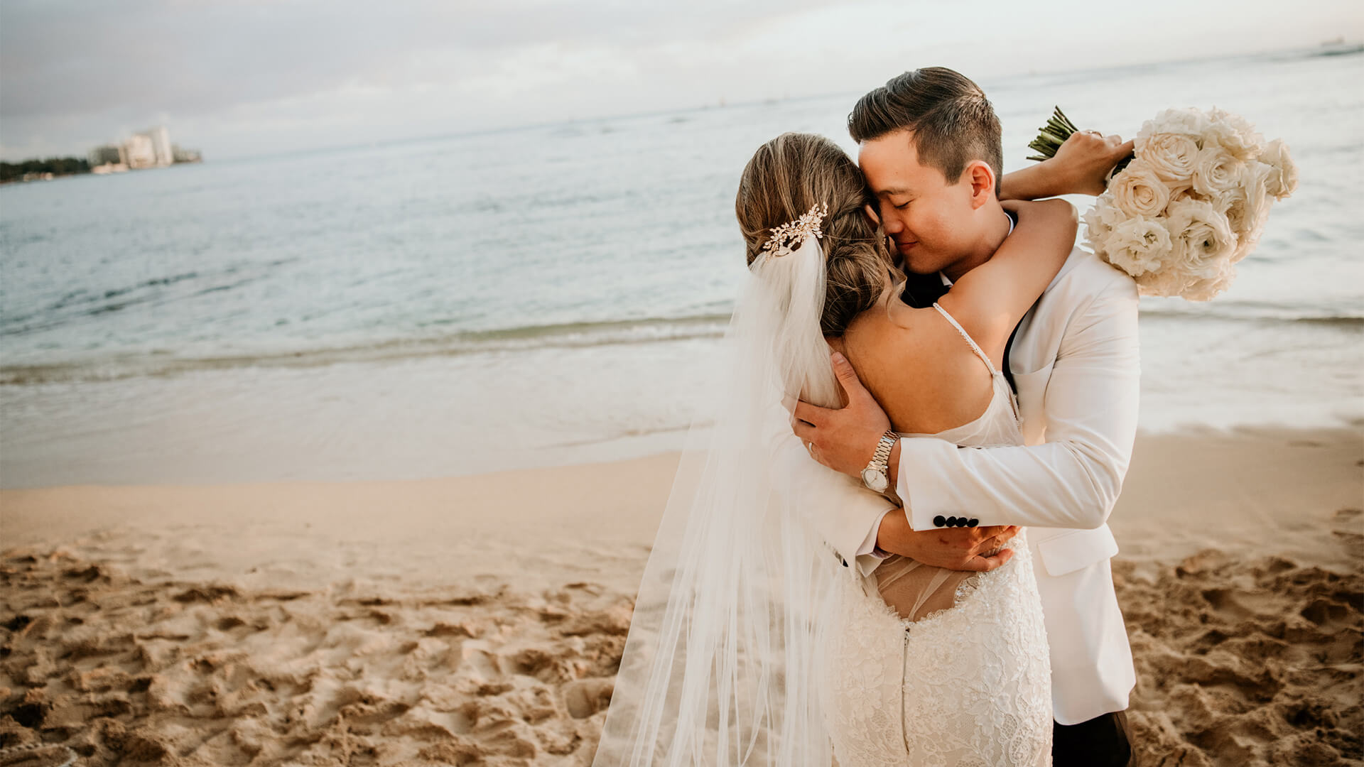 Wedding couple embrace on the beach